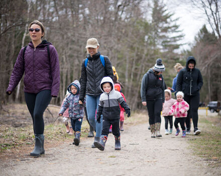 Families with young children, bundled up on a chilly day, walk down a pathway. (photo © Ben Conant)