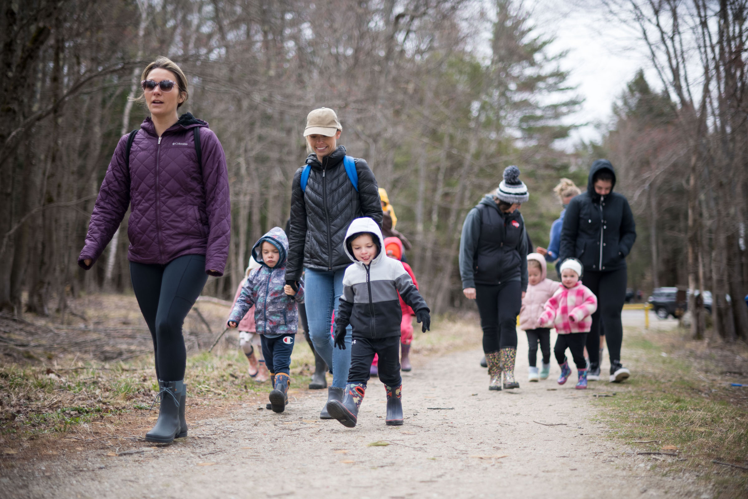 Families with young children, bundled up on a chilly day, walk down a pathway. (photo © Ben Conant)