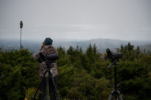 Levi Burford watches for hawks on a cloudy day atop Pack Monadnock. (photo © Ben Conant)