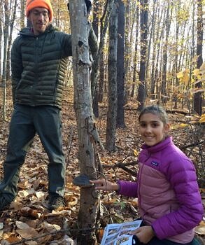 John Benjamin and a student find a mushroom in the fall woods. (photo © Laura White)