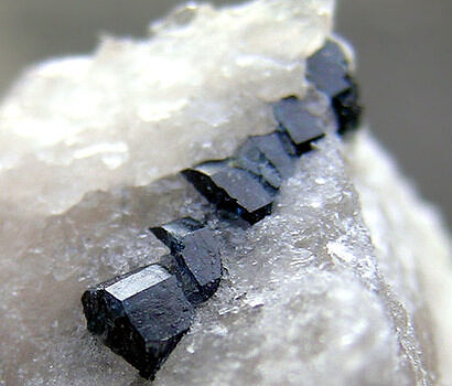 Black rocks embedded in a white rock (tourmaline). (photo © Peter Cristofono)