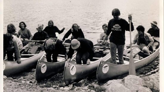 A black and white photo of a group of young women in canoes. (© The Journal)