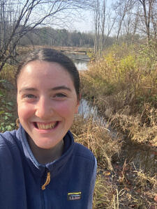 Kate McKay takes a selfie in front of a wetland.