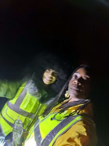 A woman and a teenage girl pose for a nighttime selfie while wearing reflective vests. (photo © LaNeia Thomas)