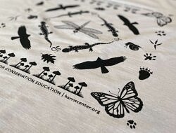 A cream-colored bandana with black silhouettes of plants and animals.
