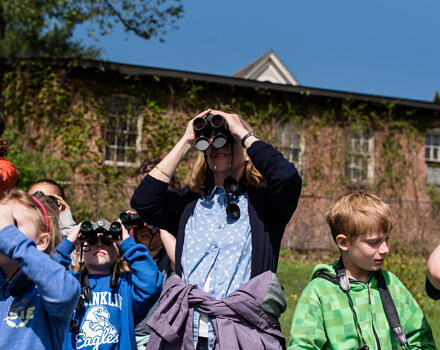 Teacher and students looking through binoculars. (Photo © Ben Conant)