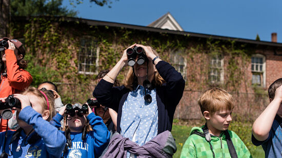 Teacher and students looking through binoculars. (Photo © Ben Conant)