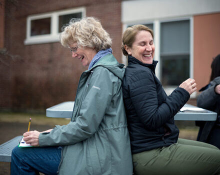 Teachers sitting and smiling during workshop game (Photo © Ben Conant)